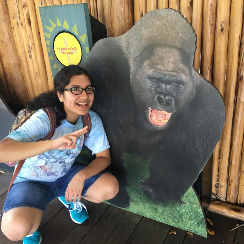 Junior Danielle Bishop poses with a cardboard cutout of a gorilla. 