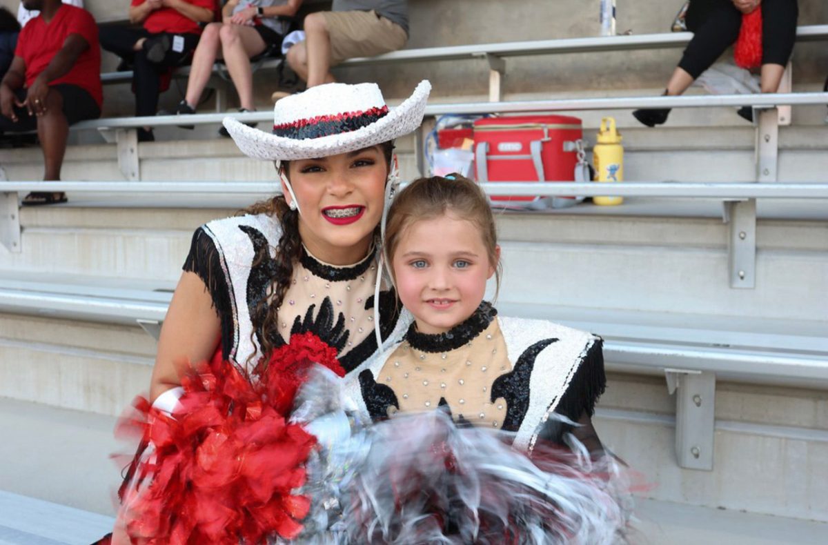 Julieann Torres, 9th, takes a picture with her Bailadora buddy during the Jersey Village game.